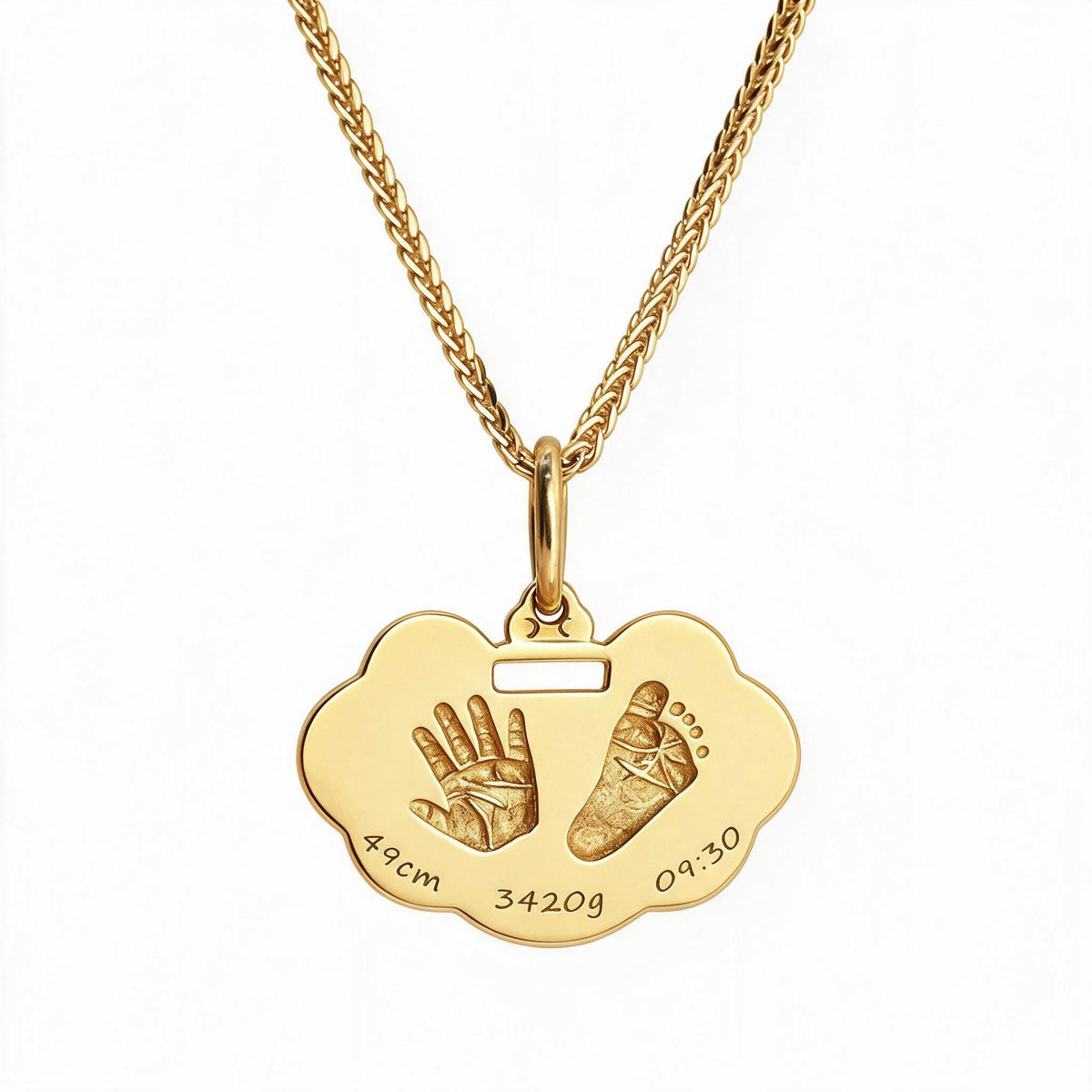 Gold-tone handprint and footprint pendant with sample birth details engraved along its lower edge.