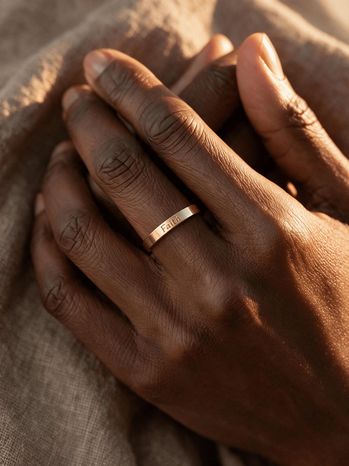 Close-up of hands wearing a personalized band with a small engraved message.