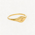 Gold-tone initial signet ring with a script Z on its curved face, shown at an angle.