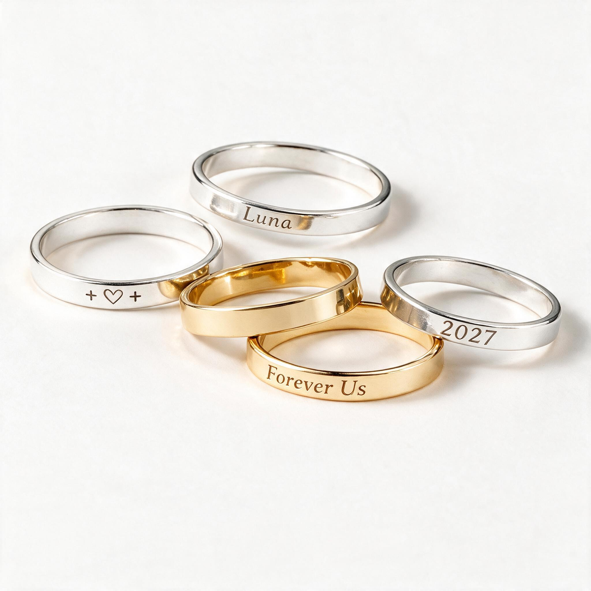 Gold-tone and silver-tone keepsake bands with sample names, a date and a heart engraving.