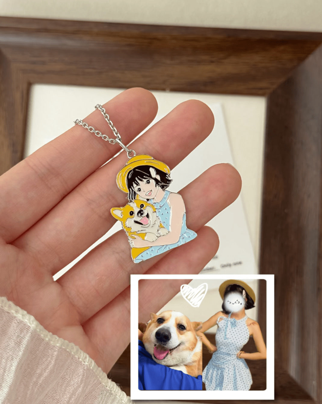 Hand holding a person-and-dog portrait pendant beside the photo that inspired it.