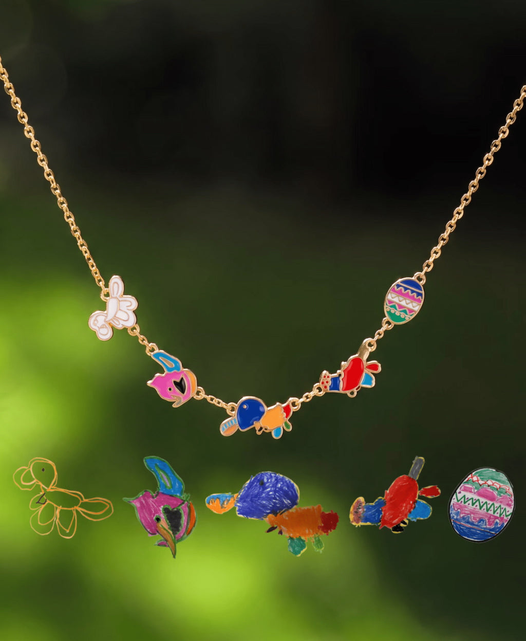 Gold-tone chain with five colorful doodle charms displayed above their original drawings.