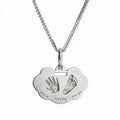 Silver-tone handprint and footprint necklace with sample birth details on the pendant.